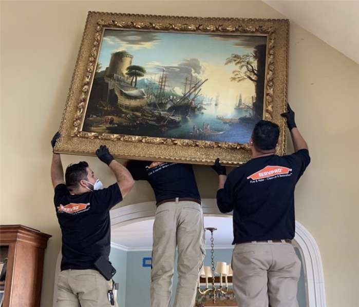 men holding a painting
